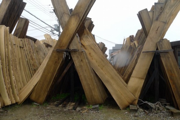 大阪泉州桐箪笥の田中家具の工房の桐材が雨に濡れています。